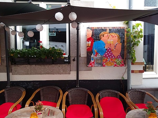 "Белый город" - вовсе не значит "однообразный": уличное кафе привлекает яркой развесёлой живописью